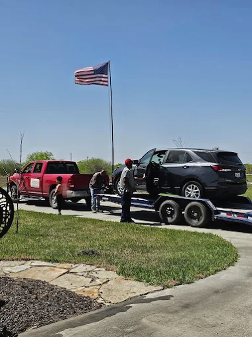 Donald loading a customer's SUV onto the trailer, American flag flying