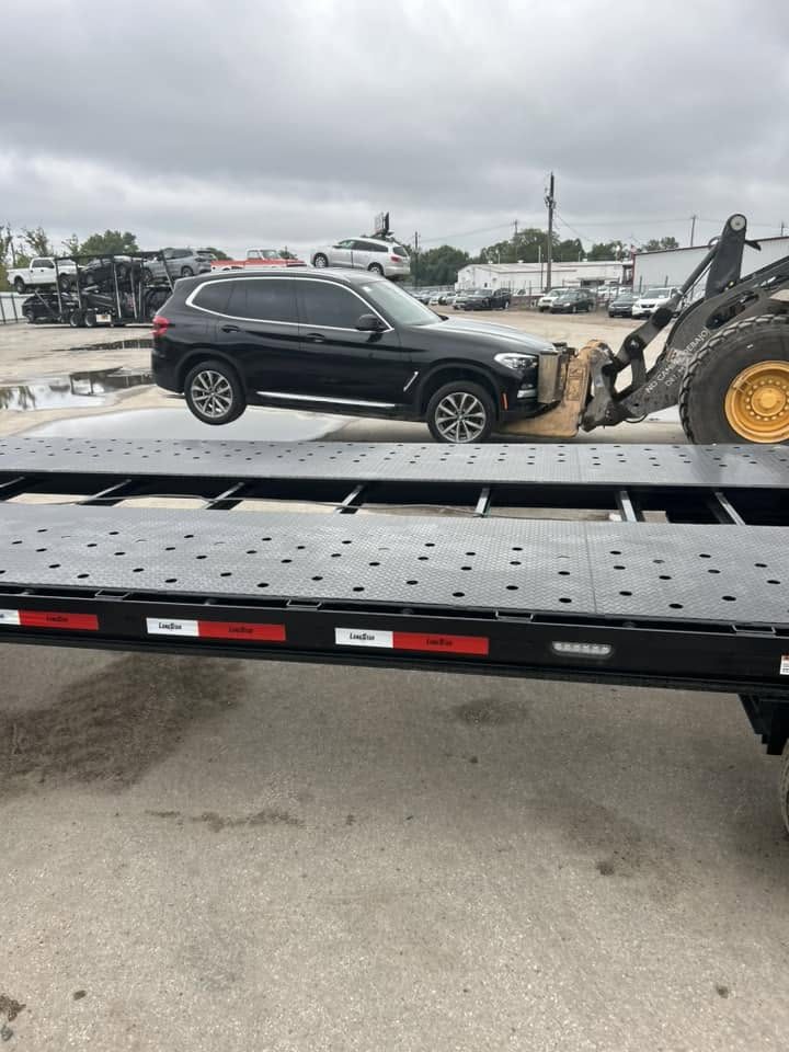 An SUV being winched up onto the flatbed for a hot shot run