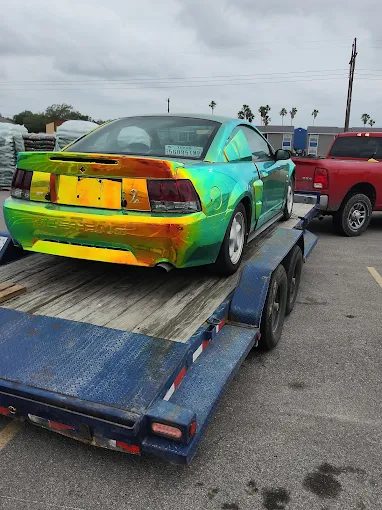 A custom color-shift Mustang loaded on the flatbed trailer
